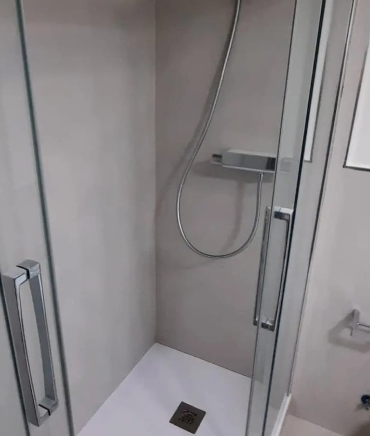 Ducha en microcemento gris con mampara