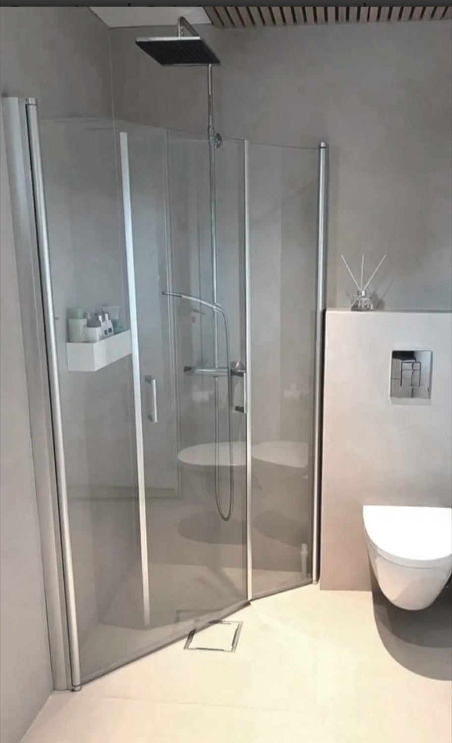 Baño en microcemento gris con ducha e inodoro suspendido
