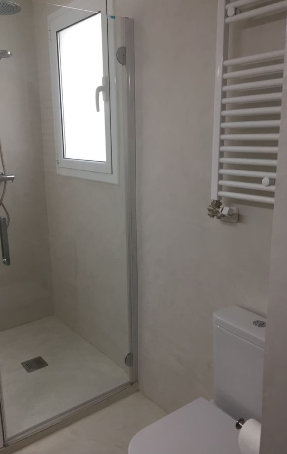 Baño en microcemento blanco con ducha