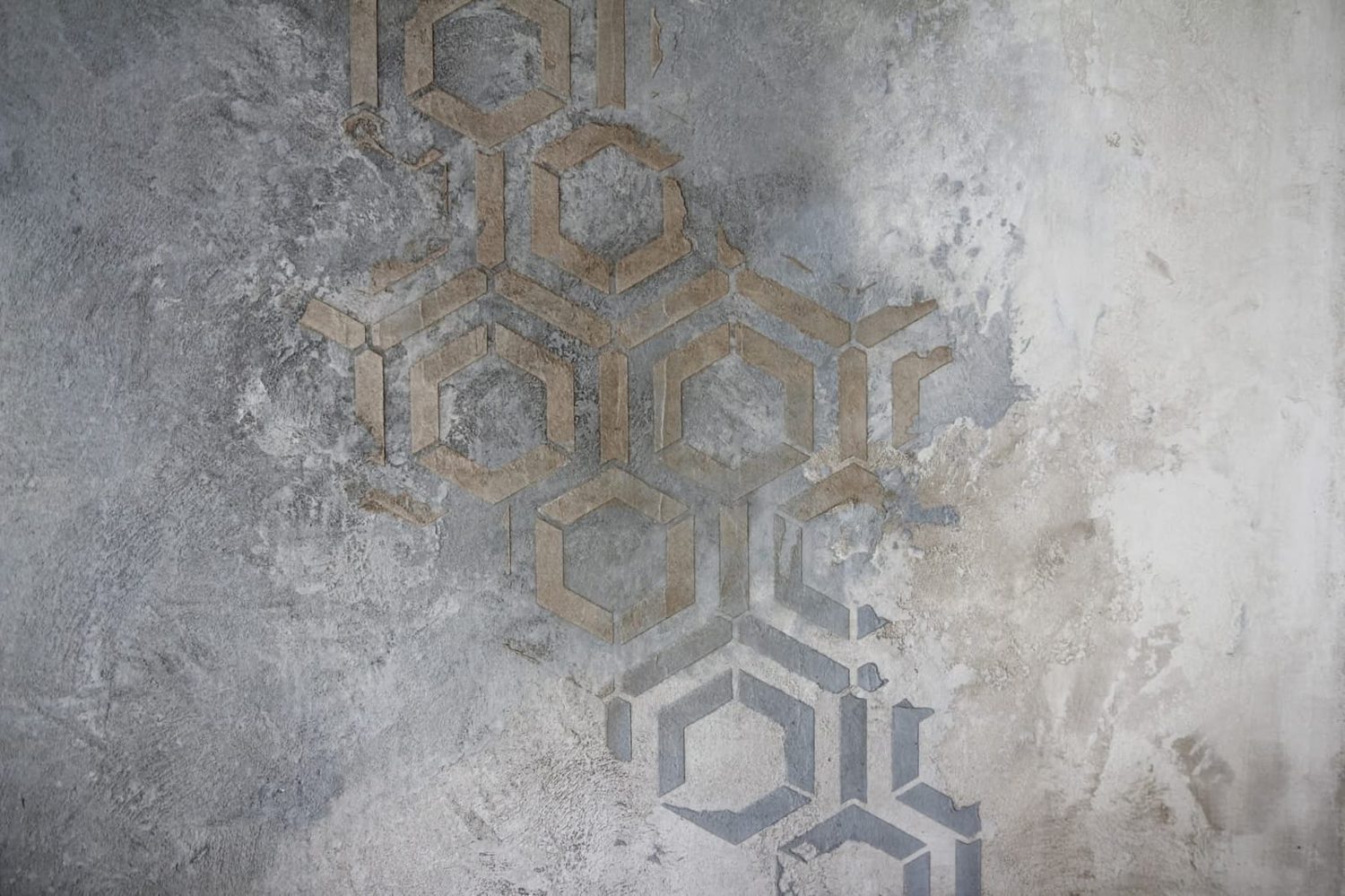 Pared amplia de microcemento gris con acabado geométrico difuminado