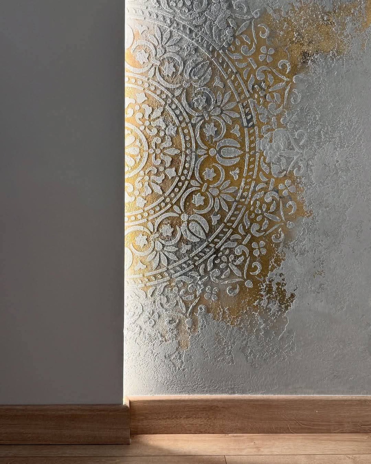 Pared decorativa con mandala dorado sobre microcemento