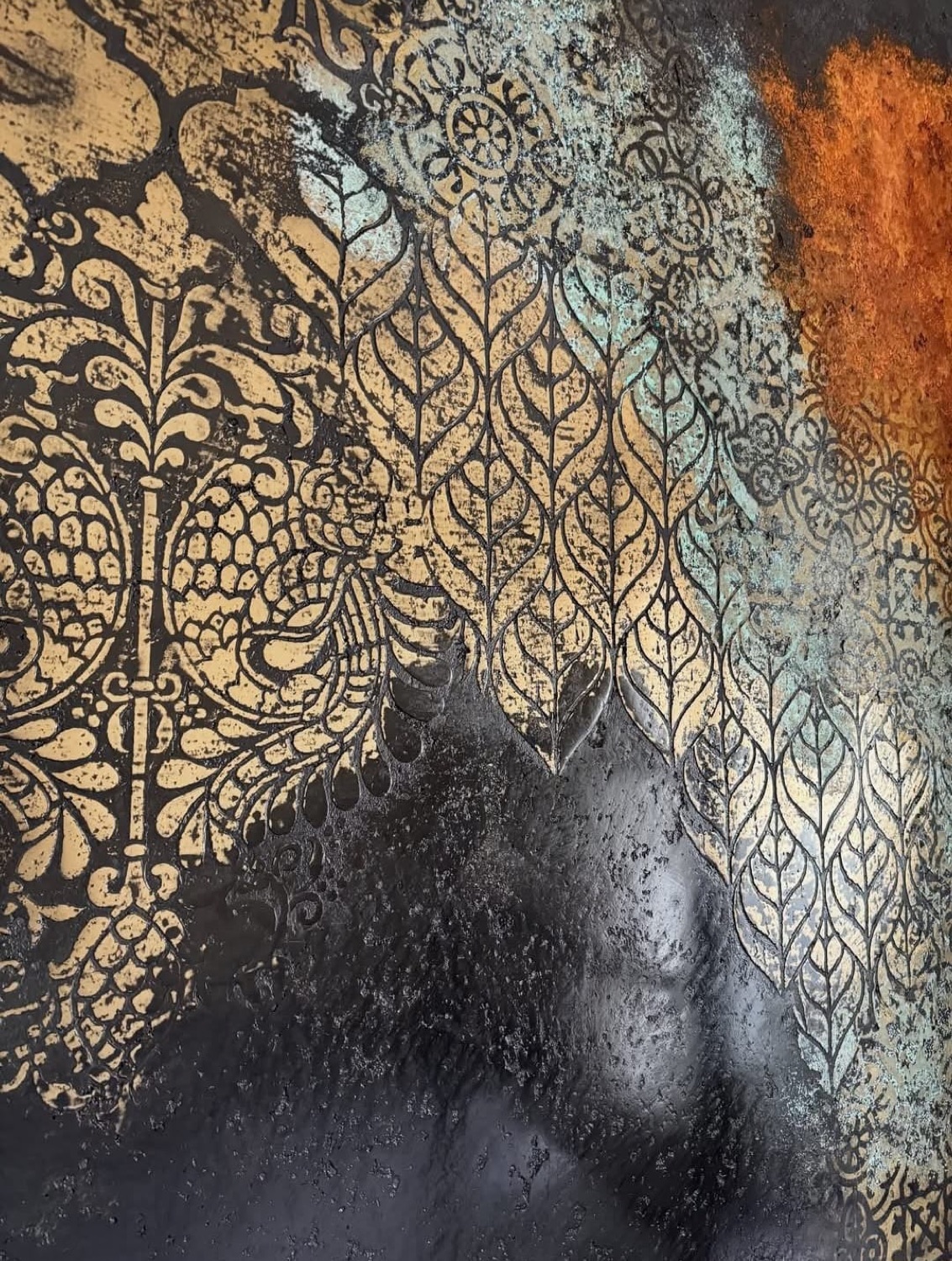 Pared negra con estarcido dorado de hojas