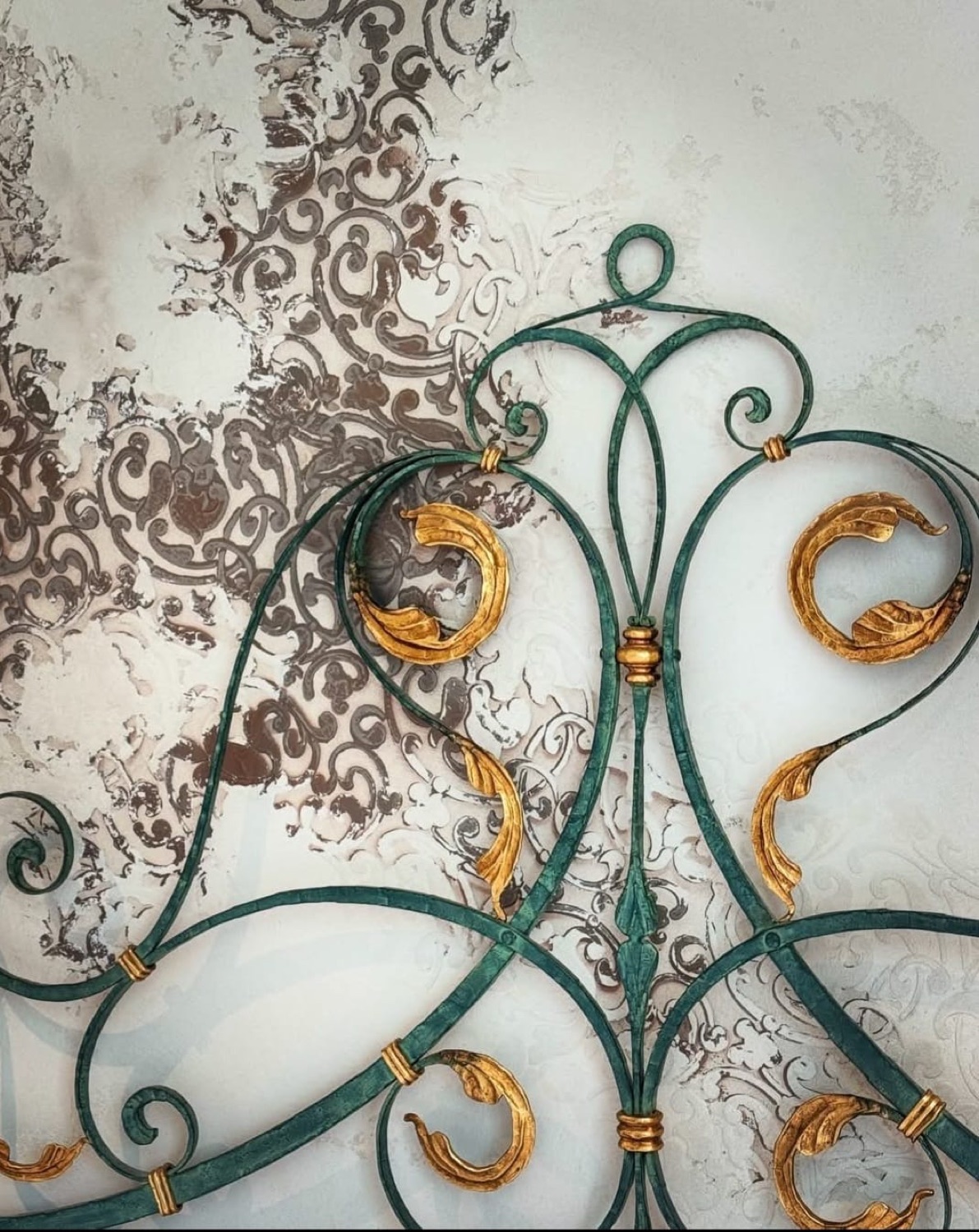 Detalle decorativo en verde y oro sobre pared